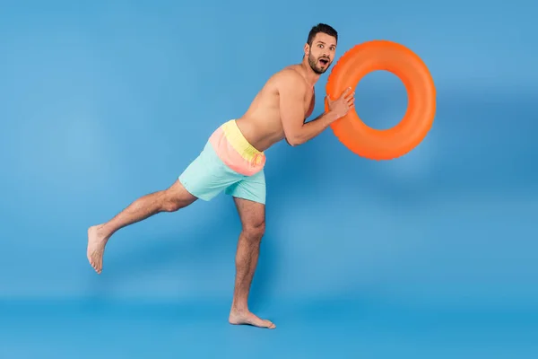 Emocionado Hombre Sin Camisa Sosteniendo Anillo Inflable Sobre Fondo Azul — Foto de Stock