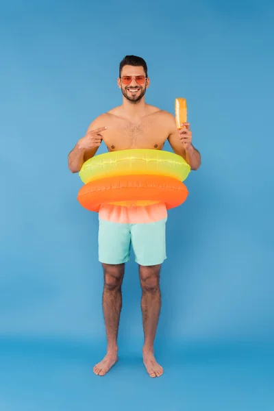 Shirtless Man Inflatable Rings Pointing Sunscreen Blue Background — Stock Photo, Image