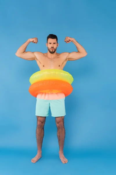 Shirtless Man Inflatable Rings Showing Muscles Blue Background — Stock Photo, Image