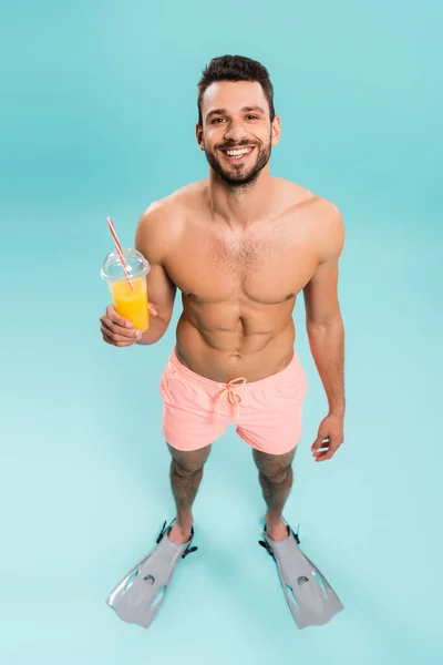 Hoge Hoek Uitzicht Van Gelukkig Shirtloze Man Zwemvliezen Met Sinaasappelsap — Stockfoto