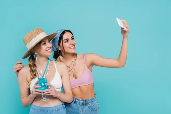 Zâmbind Femeie Luând Selfie Prieten Care Deține Cocktail Izolat Albastru — Fotografie, imagine de stoc