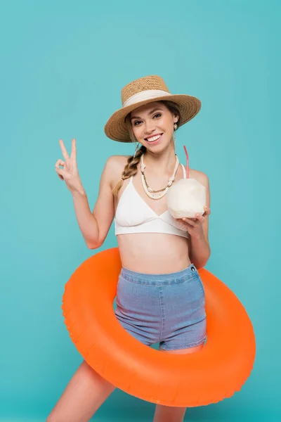 Positive Woman Swim Ring Holding Cocktail Coconut Showing Peace Gesture — Stock Photo, Image