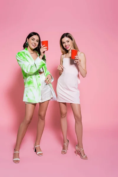 Stijlvolle Vrouwen Met Plastic Bekers Roze Achtergrond — Stockfoto