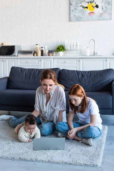 Mujer Con Interracial Hijas Viendo Película Portátil Piso —  Fotos de Stock