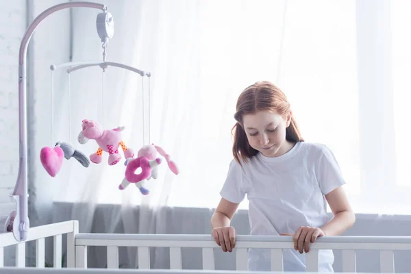 Redhead Girl Looking Crib Hanging Toys — Stock Photo, Image