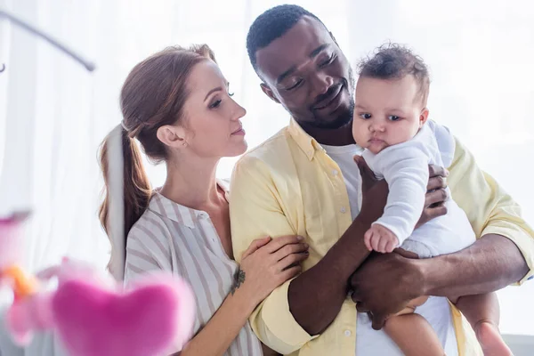 Pleased Interracial Parents Looking Baby Blurred Foreground — Stock Photo, Image