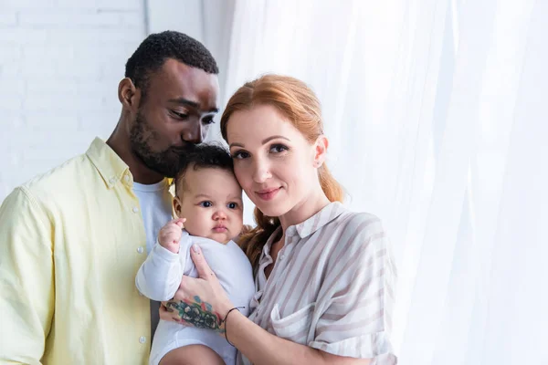 Happy Woman Looking Camera Smiling Husband Kissing Head Infant Daughter — Stock Photo, Image