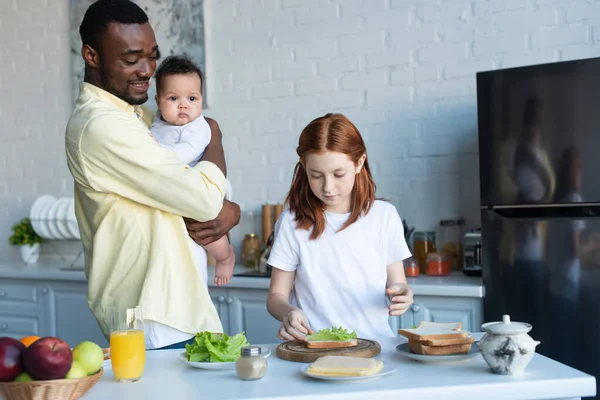 Hombre Afroamericano Feliz Con Bebé Bebé Mirando Hija Preparando Sándwiches — Foto de Stock