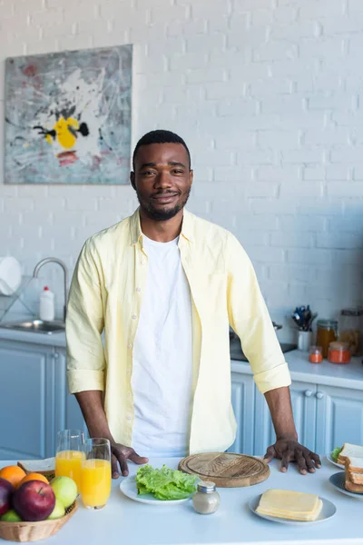 Hombre Afroamericano Positivo Pie Cerca Mesa Con Desayuno —  Fotos de Stock