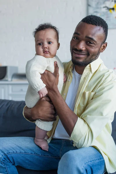 Glad Afrikansk Amerikansk Man Tittar Kameran Medan Sitter Soffan Med — Stockfoto