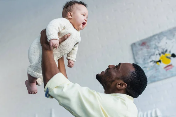 Africano Americano Hombre Criando Excitado Bebé Mientras Tener Divertido Casa — Foto de Stock