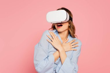 VR kulaklıklı korkmuş kadın pembeyle izole edilmiş. 