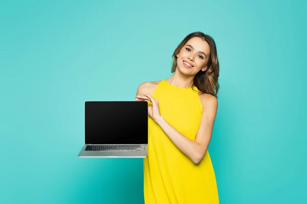 Happy Woman Yellow Dress Showing Laptop Blank Screen Blue Background — Stock Photo, Image