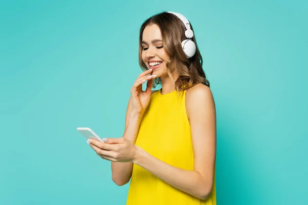 Mulher Sorridente Fones Ouvido Usando Smartphone Isolado Azul — Fotografia de Stock