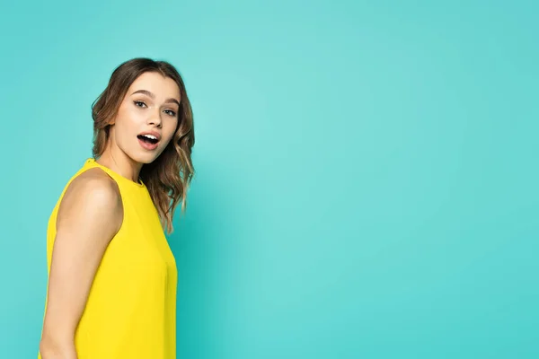 Astonished Woman Yellow Dress Looking Camera Isolated Blue — Stock Photo, Image