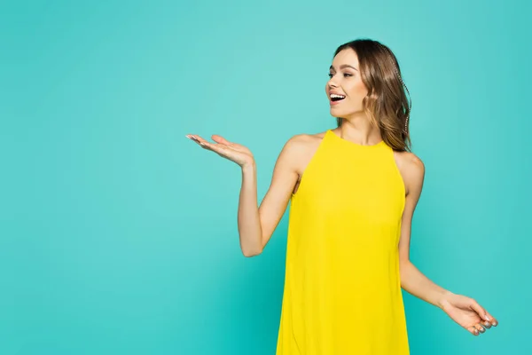 Cheerful Woman Yellow Dress Pointing Hand Isolated Blue — Stock Photo, Image