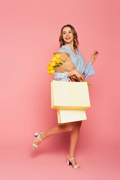 Mujer Alegre Sosteniendo Ramo Bolsas Compras Sobre Fondo Rosa —  Fotos de Stock