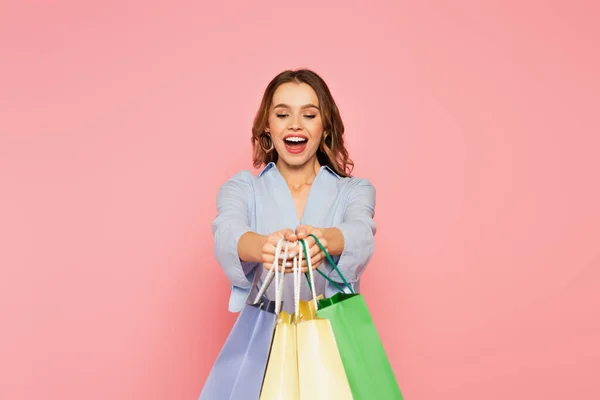 Aufgeregter Ladendieb Hält Einkaufstüten Isoliert Auf Rosa — Stockfoto