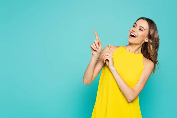 Smiling Woman Yellow Dress Pointing Fingers Isolated Blue — Stock Photo, Image