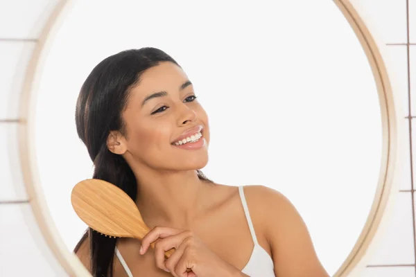 Sonriente Joven Afroamericana Mujer Cepillando Pelo Cerca Del Espejo Baño — Foto de Stock