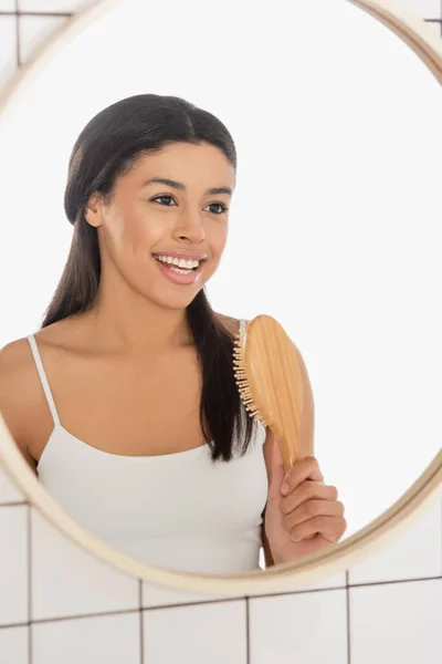 Sonriente Joven Afroamericana Mujer Sosteniendo Cepillo Pelo Cerca Del Espejo — Foto de Stock