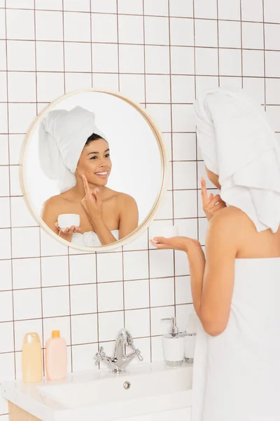 Young African American Woman Wrapped Towels Applying Cream Face Mirror — Stock Photo, Image