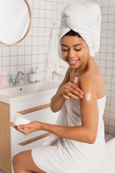 Joven Afroamericana Mujer Sosteniendo Tarro Aplicando Crema Brazo Baño —  Fotos de Stock