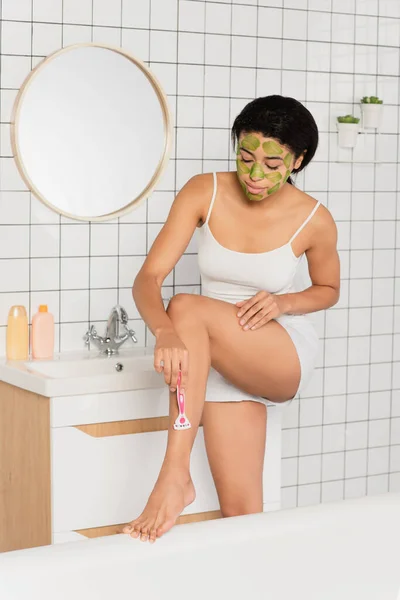 Young African American Woman Scrub Face Shaving Leg Razor Bathroom — Stock Photo, Image