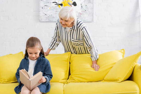 Sonriente Abuelita Pie Cerca Niño Leer Libro Casa — Foto de Stock