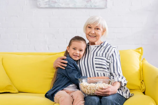 Sonriente Abuela Con Palomitas Maíz Abrazando Niño Sofá — Foto de Stock