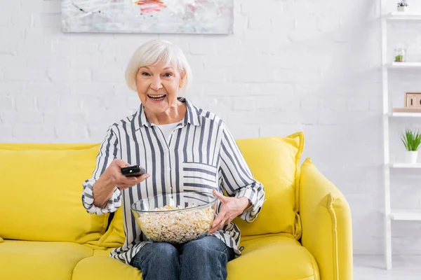 Mujer Mayor Positiva Sosteniendo Mando Distancia Palomitas Maíz Casa — Foto de Stock