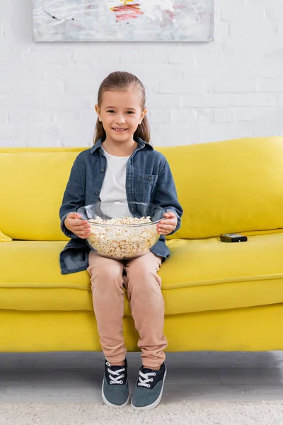 Dítě Popcornem Usmívá Kameru Poblíž Dálkového Ovladače Gauči — Stock fotografie