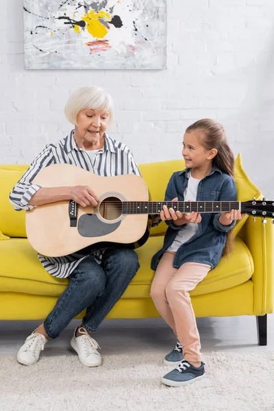 Χαρούμενη Γιαγιά Και Παιδί Που Παίζουν Ακουστική Κιθάρα Στον Καναπέ — Φωτογραφία Αρχείου
