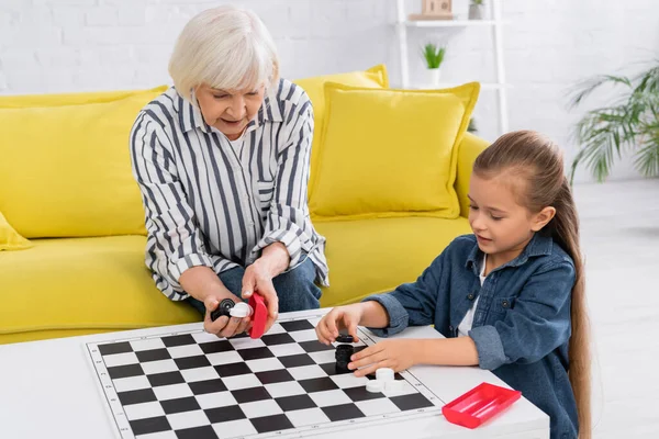 Granny Holding Checkers Child Coffee Table Living Room — Stock Photo, Image