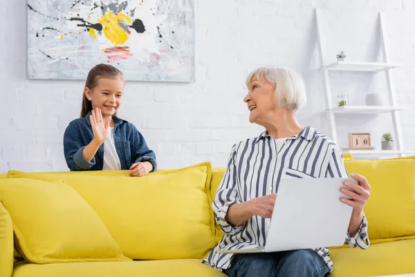 Mormor Med Bärbar Dator Ler Mot Barnet Videosamtal Hemma — Stockfoto