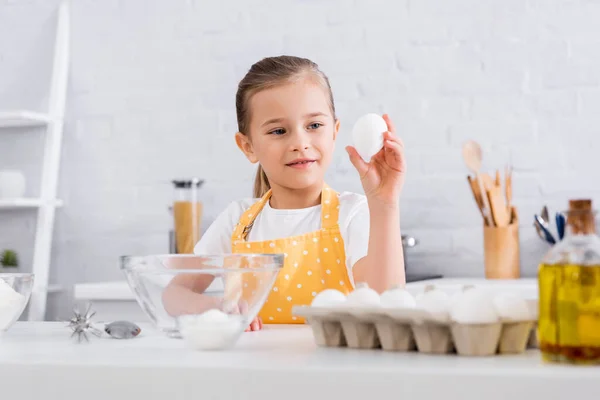 Criança Sorridente Segurando Ovo Perto Açúcar Óleo Primeiro Plano Desfocado — Fotografia de Stock