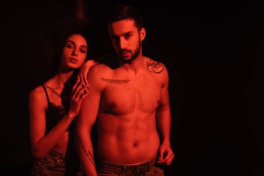 Afrikalı Amerikalı bir kadın, siyah bir erkek arkadaşa sarılıyor. 