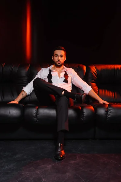 Bearded Man Formal Wear Looking Camera Couch Black Background Red — Stock Photo, Image