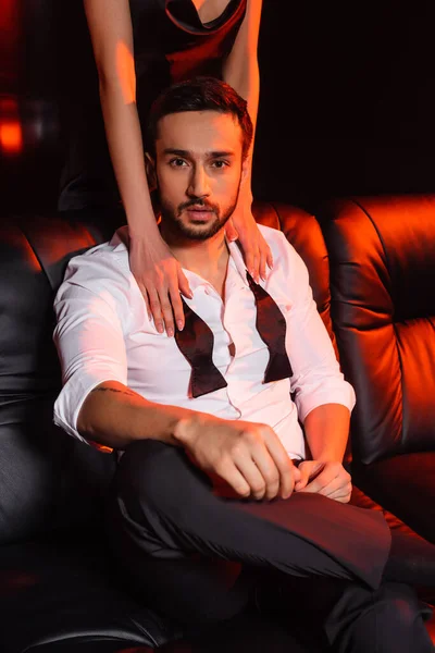 Young Woman Touching Bearded Boyfriend Couch Black Background Red Lighting — Stock Photo, Image