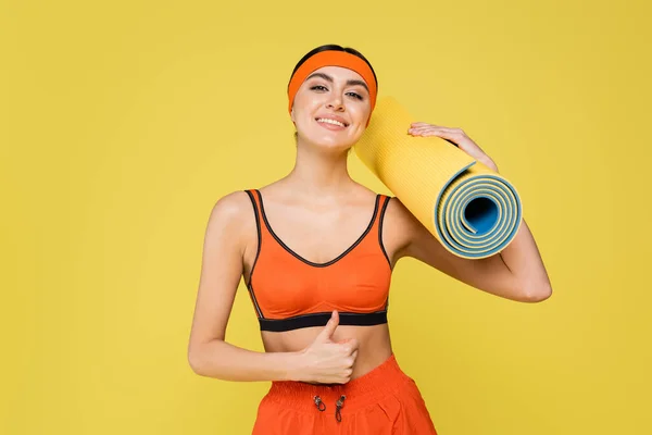 Cheerful Sportswoman Fitness Mat Showing Thumb Isolated Yellow — 스톡 사진