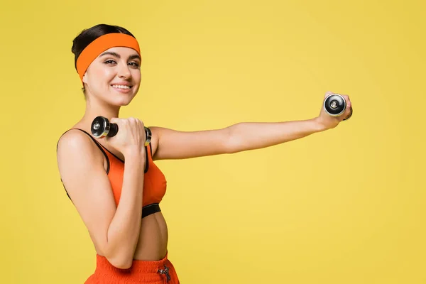 Tevreden Vrouw Glimlachen Camera Tijdens Het Sporten Met Halters Geïsoleerd — Stockfoto