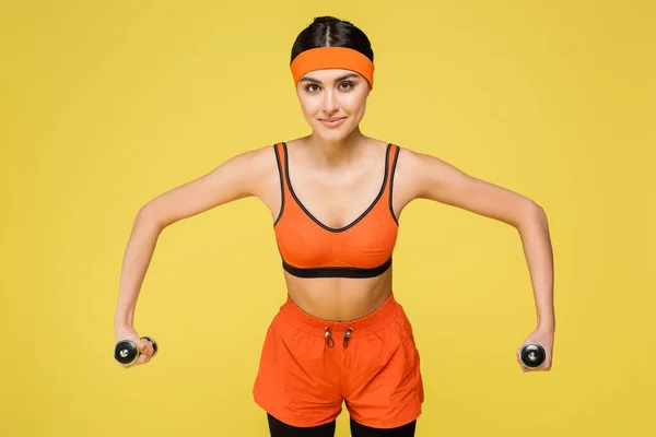 Young Sportswoman Orange Sportswear Training Dumbbells Isolated Yellow — 스톡 사진