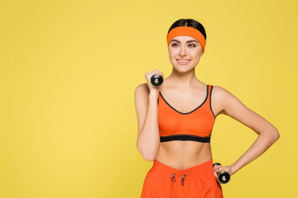 Smiling Sportswoman Hand Hip Holding Dumbbells Isolated Yellow —  Fotos de Stock