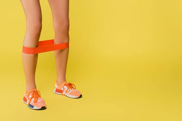Sarı Arka Planda Bacaklarında Direnç Bandı Olan Sporcu Kadın Eğitiminin — Stok fotoğraf