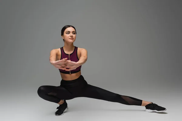 Young Woman Black Sportswear Stretching Grey Background — 스톡 사진
