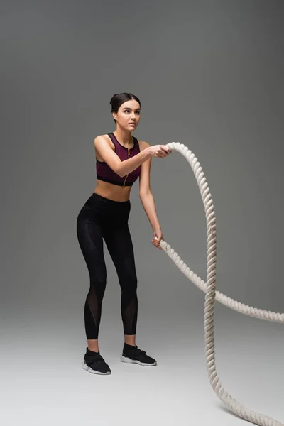 Full Length View Sportive Woman Exercising Battle Ropes Grey Background — Stock Photo, Image