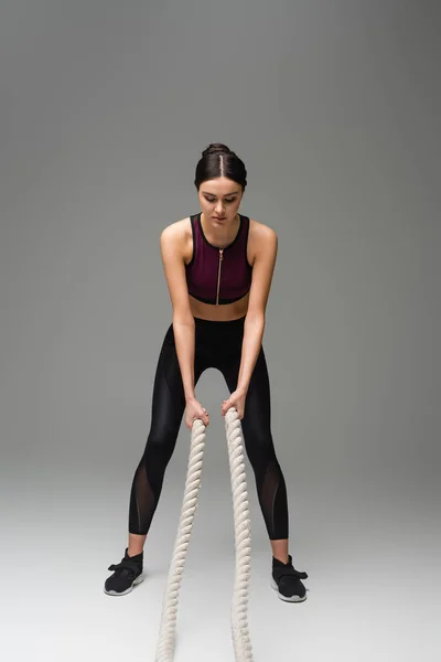 Young Woman Black Sportswear Working Out Battle Ropes Grey Background — 스톡 사진