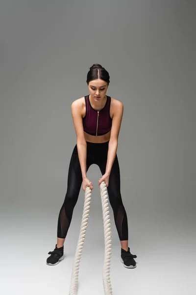 Young Woman Black Sportswear Working Out Battle Ropes Grey Background — Stock Photo, Image