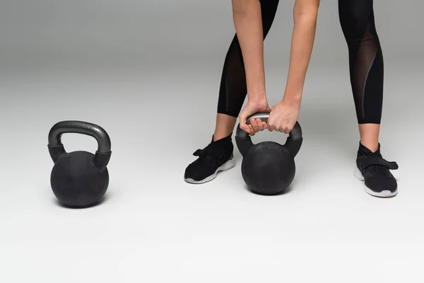 Cropped View Sportswoman Lifting Kettlebell Grey Background — 스톡 사진