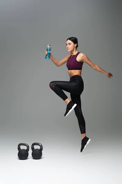 Young Woman Sports Bottle Training Kettlebells Grey Background — 스톡 사진